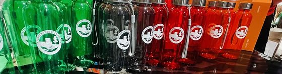 Botellas de colores con el escudo del Ayuntamiento de La Adrada