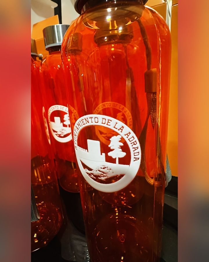 Detalle del escudo del Ayuntamiento de La Adrada sobre una botella naranja