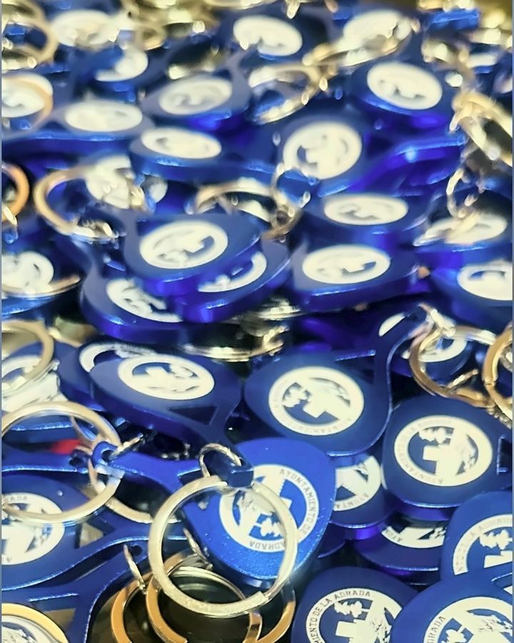 Detalle de los llaveros azules con el logotipo grabado