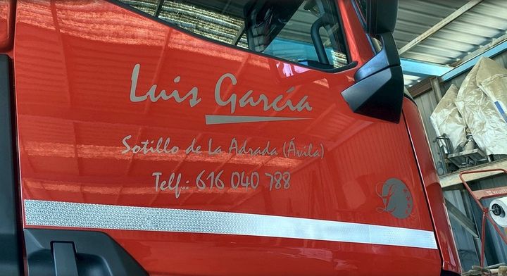 Lateral de cabina con nombre, datos de contacto y banda reflectante