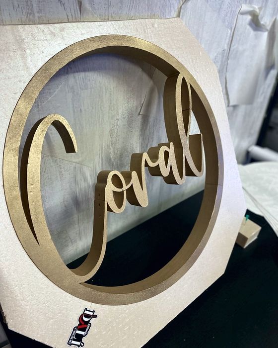 Rótulo circular Coral con letra manuscrita y aro dorado