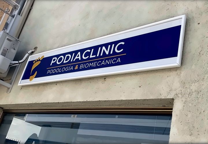 Rótulo de Podiaclinic, podología y biomecánica, sobre la entrada